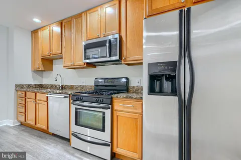 a kitchen with stainless steel appliances granite countertop a stove and a microwave