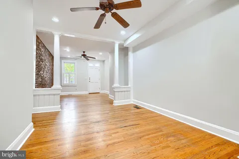 a view of an empty room with window and wooden floor