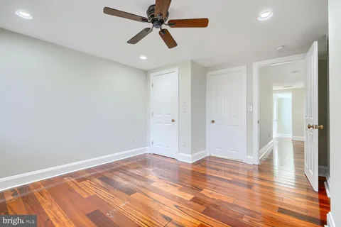 a view of room with wooden floor and ceiling fan
