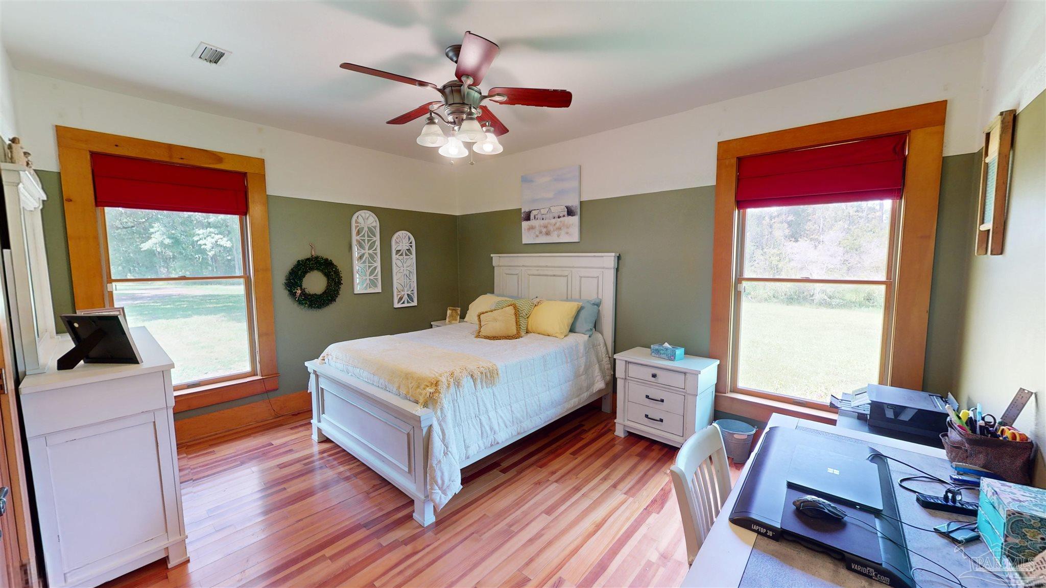 3375 Robinson Point Road Milton, FL 32583 - Photo 21 of 50 a bedroom with a bed and wooden floor