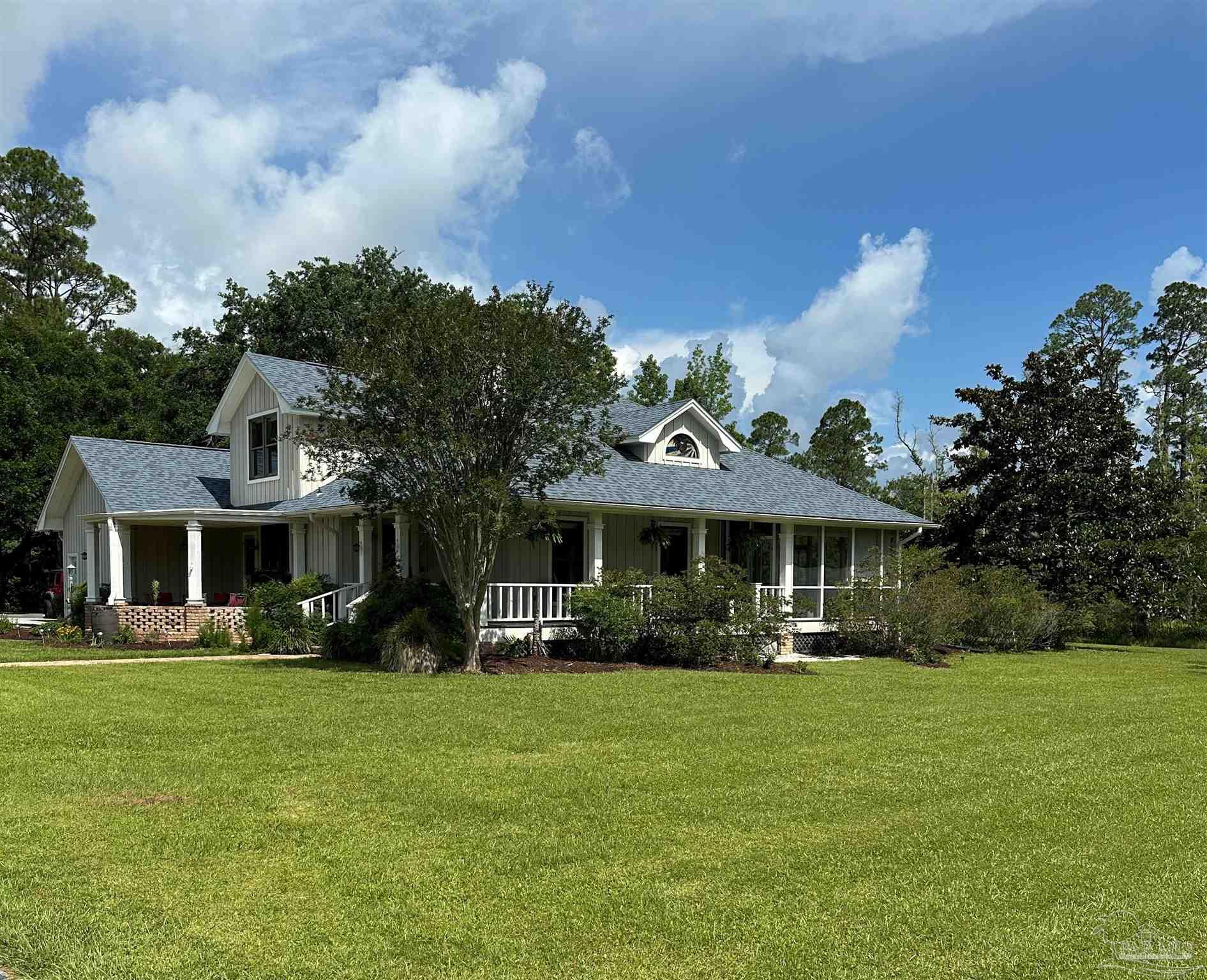 3375 Robinson Point Road Milton, FL 32583 - Photo 3 of 50 a front view of a house with garden