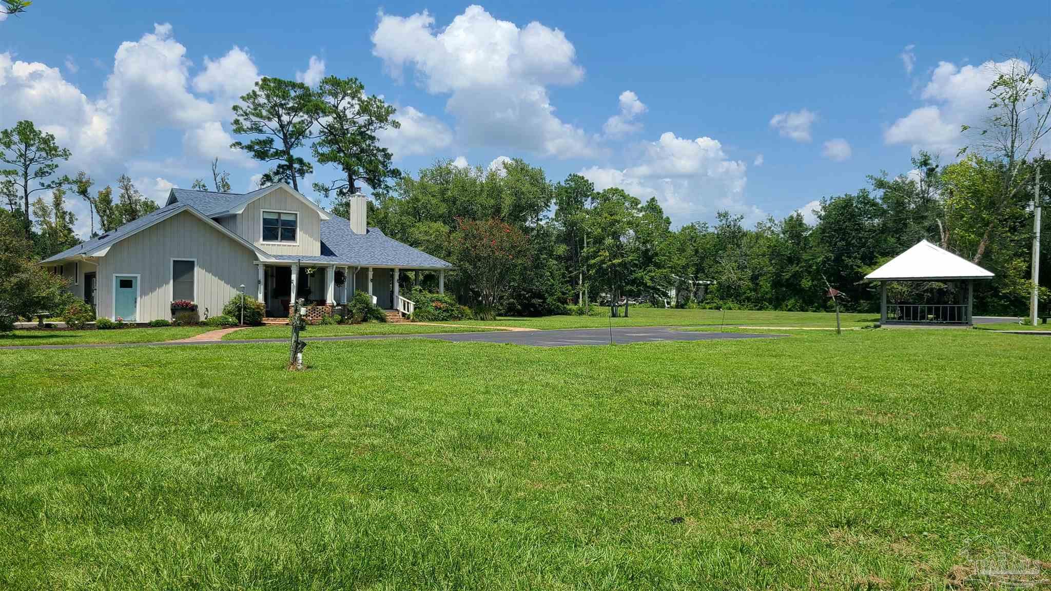 3375 Robinson Point Road Milton, FL 32583 - Photo 48 of 50 a front view of a house with garden and trees