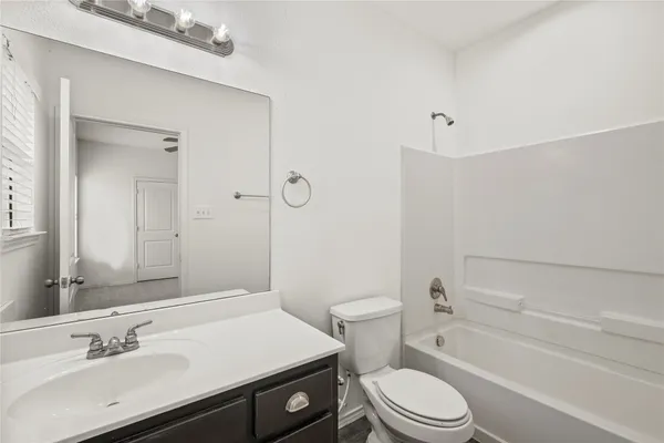 a bathroom with a sink toilet vanity and shower