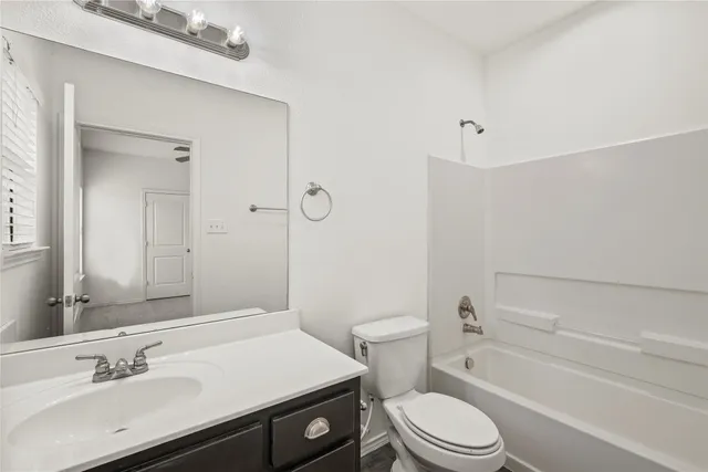 a bathroom with a sink toilet vanity and shower