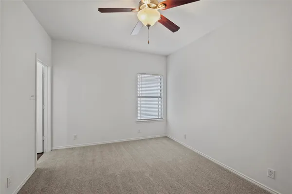a view of room with a ceiling fan and window