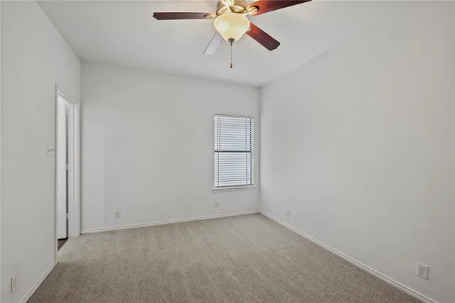 a view of room with a ceiling fan and window