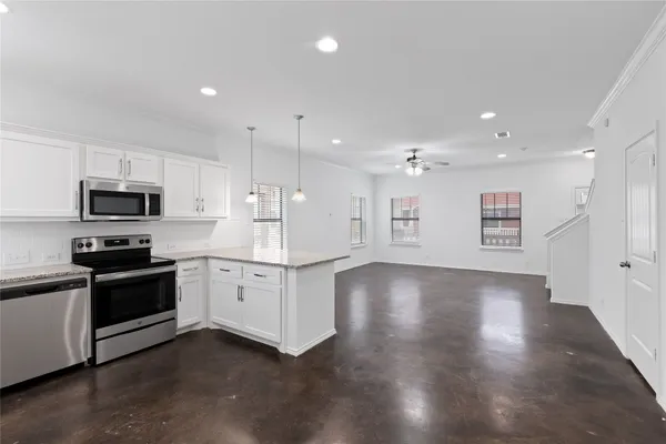 a large kitchen with stainless steel appliances kitchen island granite countertop a stove top oven a sink and dishwasher
