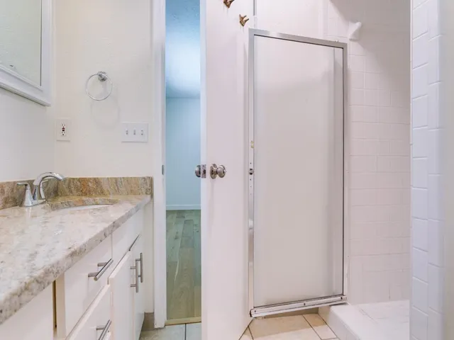 a bathroom with a granite countertop sink and a mirror