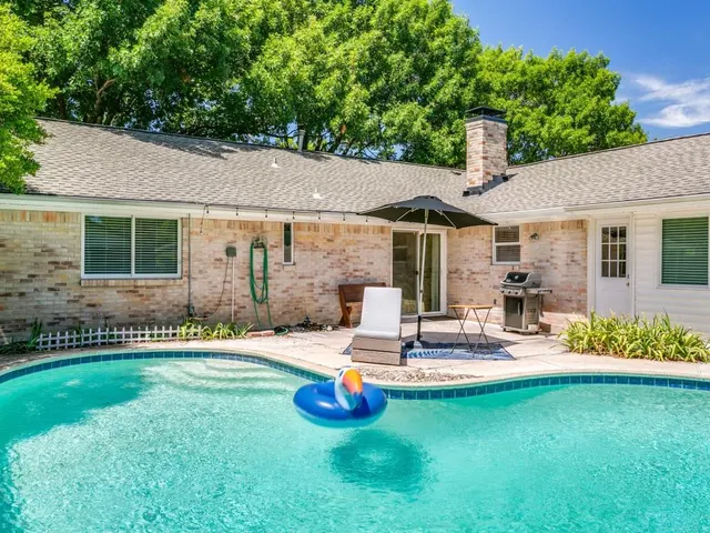 a swimming pool with outdoor seating yard and a tree