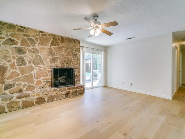 an empty room with windows and fireplace