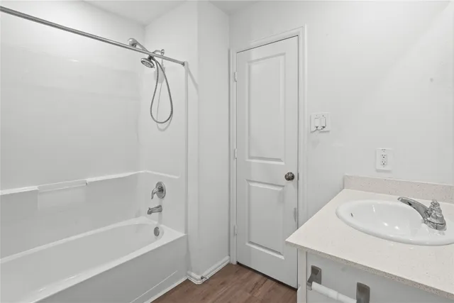 a bathroom with a granite countertop sink a mirror and a bathtub