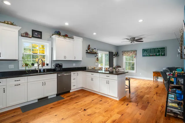 a kitchen with granite countertop white cabinets and stainless steel appliances
