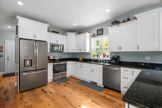 a kitchen with stainless steel appliances kitchen island granite countertop a refrigerator and microwave