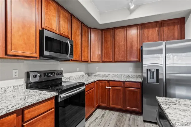 a bathroom with a granite countertop sink a toilet and a mirror