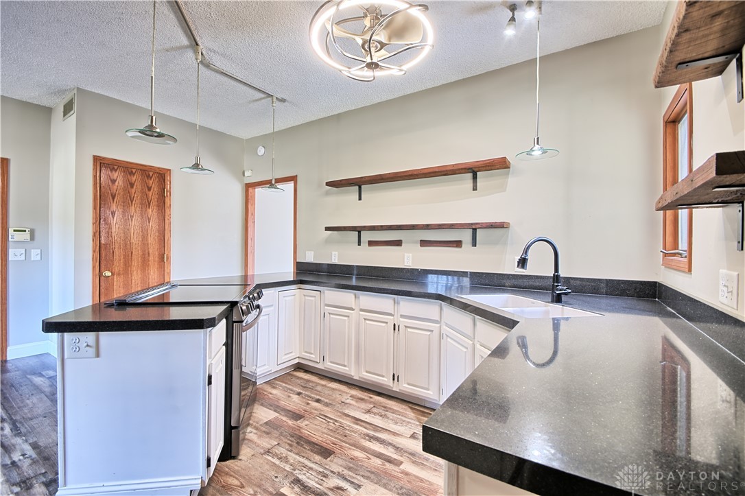 8711 Nicole Lane Springboro, OH 45066 - Photo 13 of 87 This kitchen showcases a modern design with sleek countertops and open shelving.