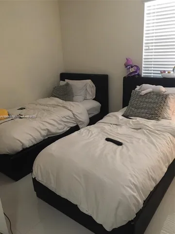 a bedroom with two beds and a window