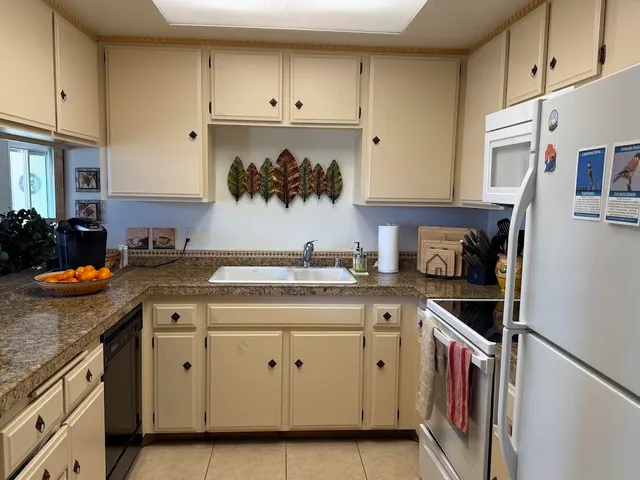 a kitchen with stainless steel appliances granite countertop a stove and white cabinets