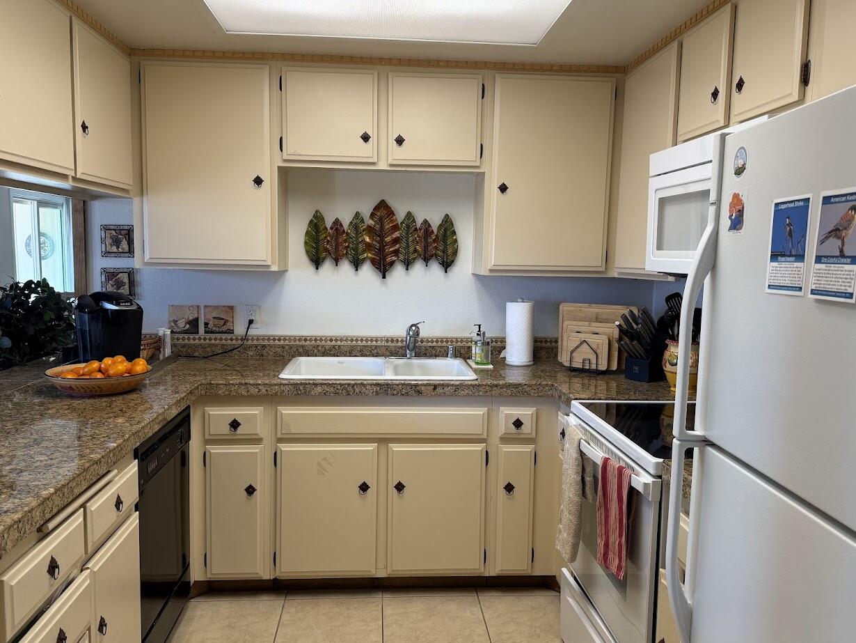 72822 Tony Trabert Lane Palm Desert, CA 92260 - Photo 12 of 23 a kitchen with stainless steel appliances granite countertop a stove a sink and a refrigerator