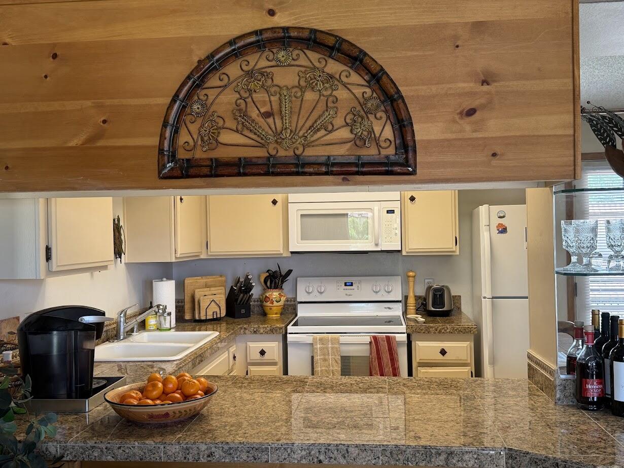 72822 Tony Trabert Lane Palm Desert, CA 92260 - Photo 13 of 23 a kitchen with stainless steel appliances granite countertop a stove and white cabinets