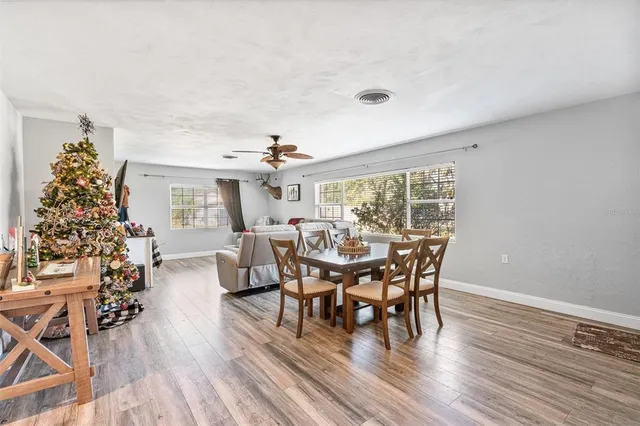 a dining room with furniture wooden floor a rug and a chandelier