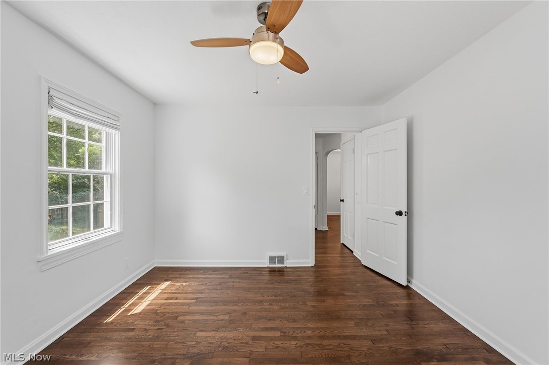 7750 Lewis Road Olmsted Falls, OH 44138 - Photo 27 of 50 Room featuring wood-finish flooring, a double-hung window with a striped roller shade, a ceiling fan with light fixture, and white painted walls