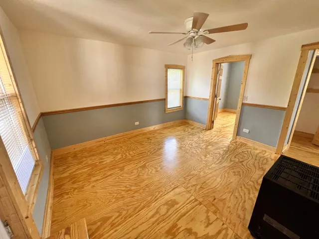 a view of a big room with wooden floor and a window