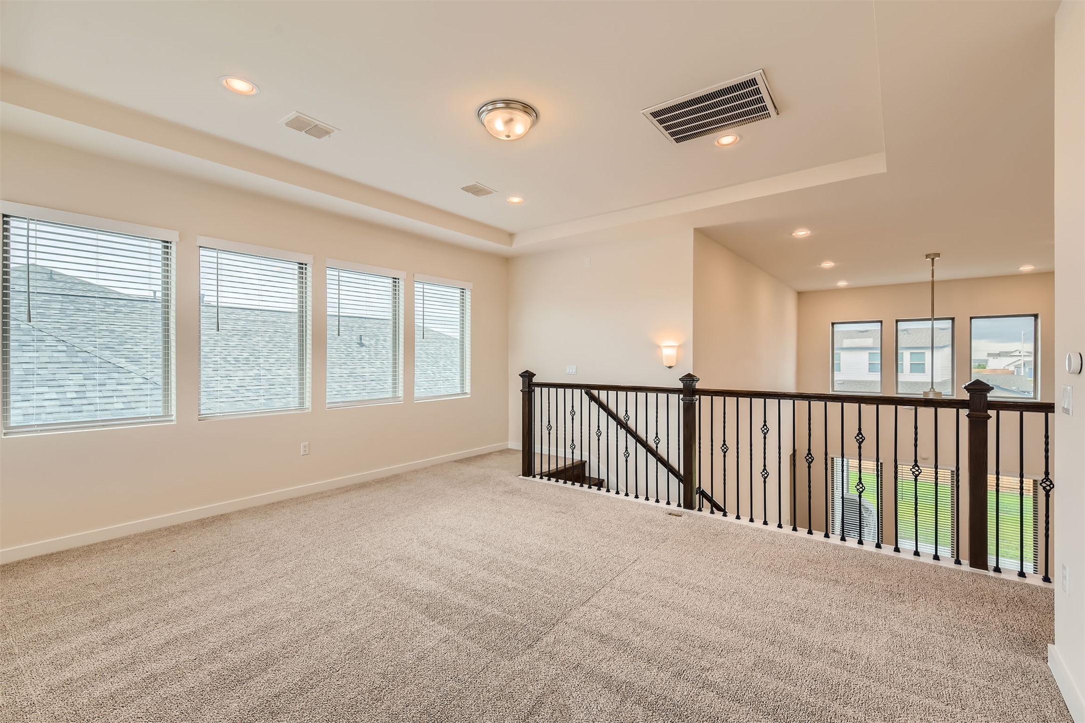 8313 Spire View Austin, TX 78744 - Photo 25 of 33 A well-lit upper-level flex space offers versatile living options with multiple windows and comfortable carpeting.
