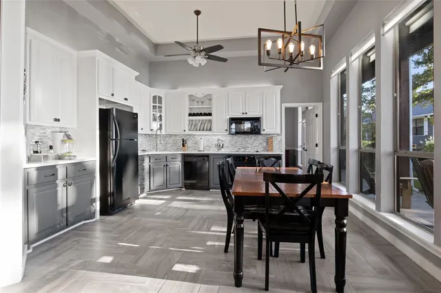 a kitchen with stainless steel appliances a dining table chairs and refrigerator