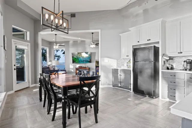 a kitchen with refrigerator dining table and wooden floor