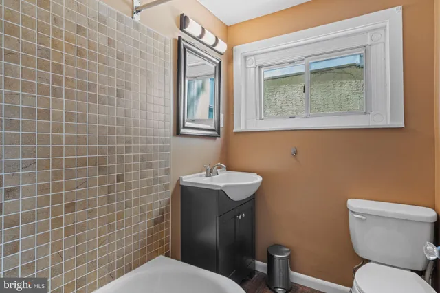 a bathroom with a white bath tub a sink and a mirror