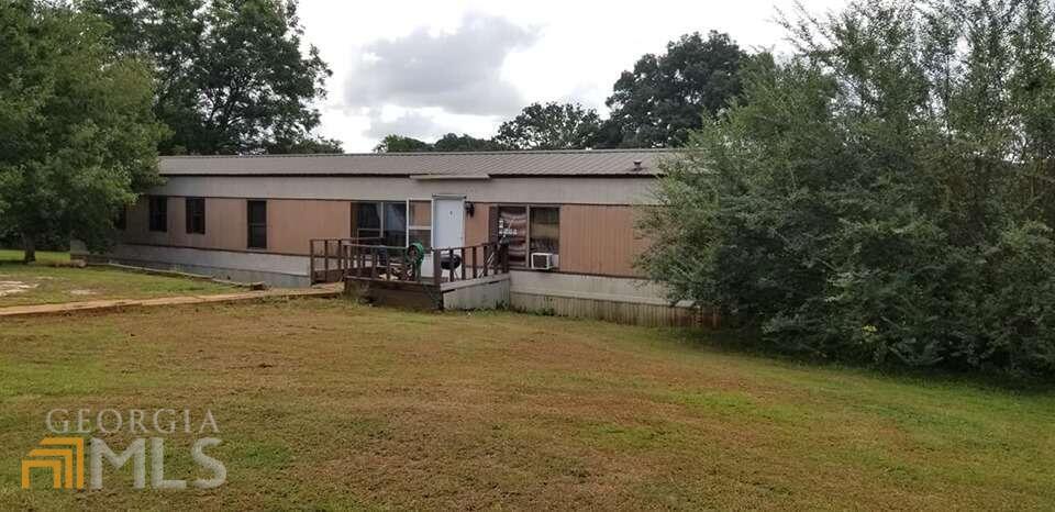 211 Settlement Road Commerce, GA 30529 - Photo 1 of 1 a view of a patio with table and chairs with wooden fence and plants