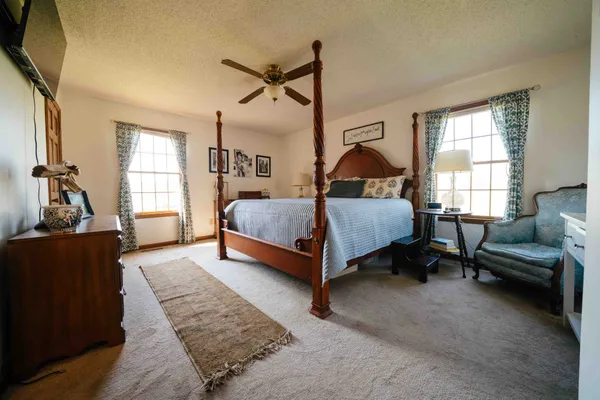 a bedroom with a bed and a dresser next to a window