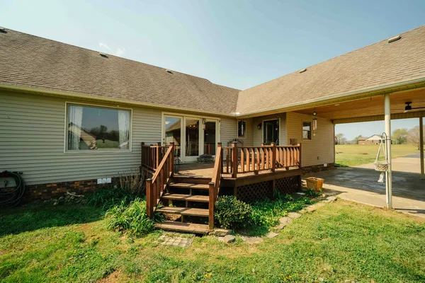 a view of a house with wooden deck and a yard