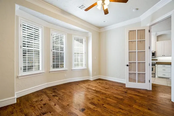 a view of an empty room with a window and wooden floor