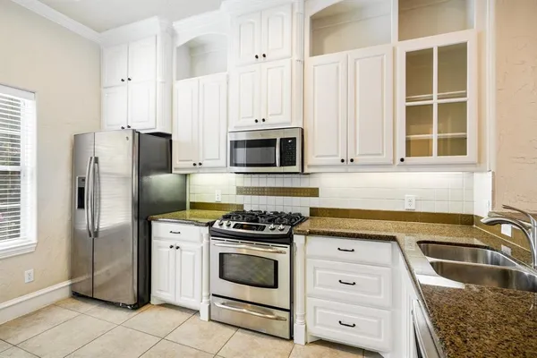 a kitchen with white cabinets and stainless steel appliances