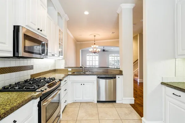 a kitchen with stainless steel appliances granite countertop a stove a sink and a microwave