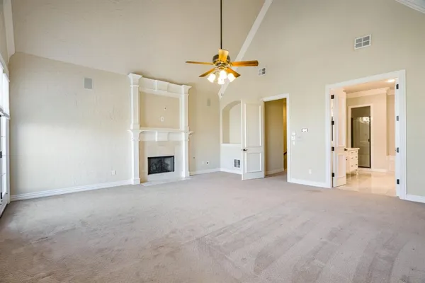 a view of a room with a ceiling fan and a fireplace