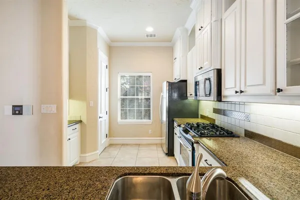 a kitchen with stainless steel appliances granite countertop a sink stove and cabinets