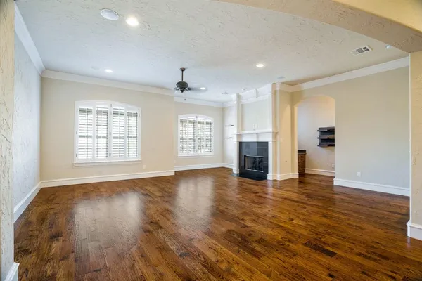 a view of empty room with wooden floor and fireplace
