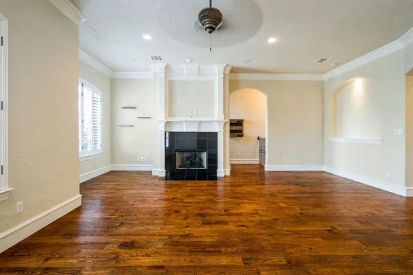 a view of empty room with wooden floor and fireplace