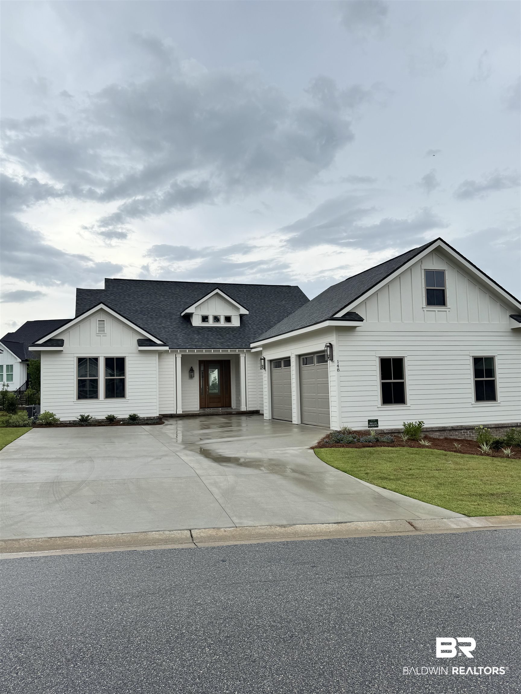 148 Hyacinth Street Fairhope, AL 36532 - Photo 2 of 2 Modern farmhouse featuring board and batten siding, an attached garage, a front yard, driveway, and roof with shingles