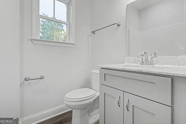a bathroom with a sink toilet vanity and window