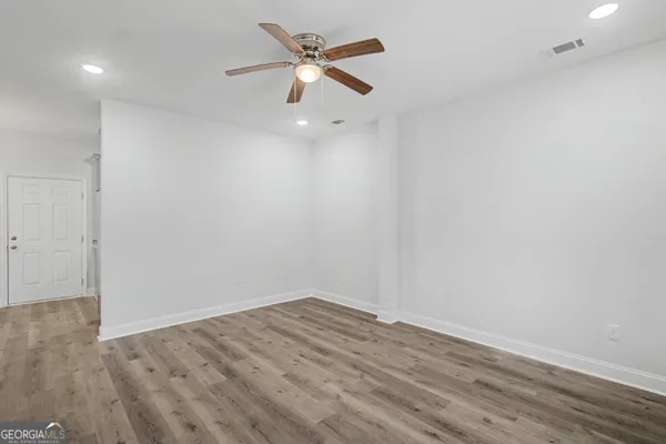 an empty room with a window and a ceiling fan