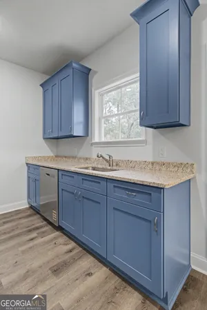 a kitchen with granite countertop wooden cabinets a sink and dishwasher