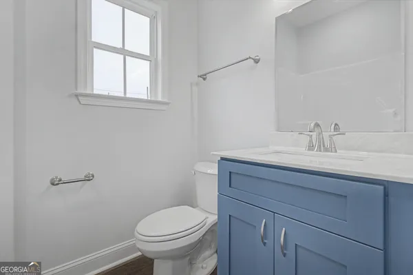 a bathroom with a sink a toilet and a window
