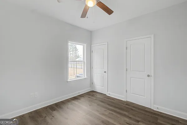 an empty room with a window and a ceiling fan