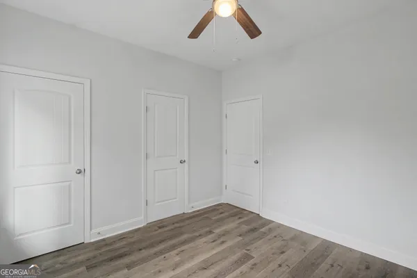 a view of empty room with wooden floor