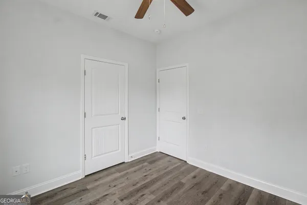 a view of an empty room with wooden floor