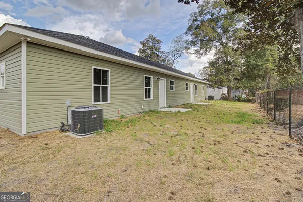 a backyard of a house with yard and brick wall