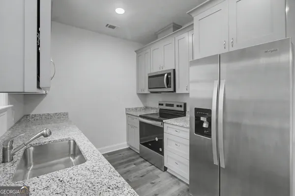 a kitchen with a sink cabinets and stainless steel appliances